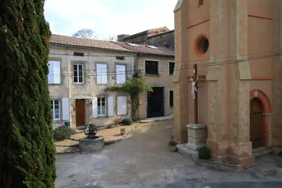 an empty courtyard of a building with a church at Cuq en Terrasses in Cuq-Toulza