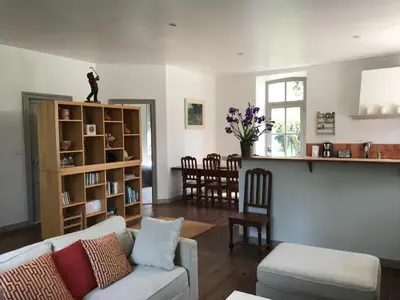 a living room with a couch and a kitchen with a counter at Pavillon de Villefrancou in Montlaur