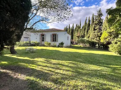 a white house in a yard with trees and grass at Pavillon de Villefrancou in Montlaur