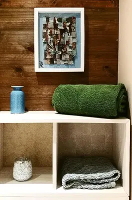 a white shelf with a green pillow and a picture at Maison de Textile Apartment in Montolieu