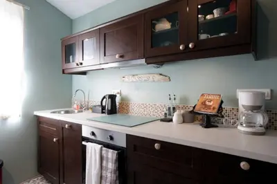 a kitchen with wooden cabinets and a counter top at Maison de Textile Apartment in Montolieu