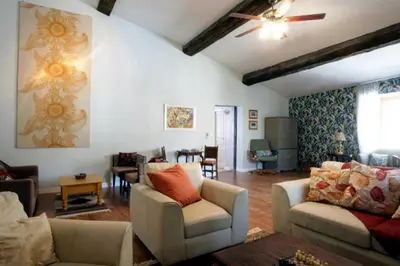 a living room with couches and a ceiling fan at Maison de Textile Apartment in Montolieu