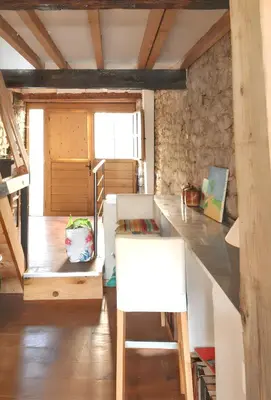 a room with a counter and a table with a chair at Maison de campagne avec vue sur la montagne à Puivert. in Puivert