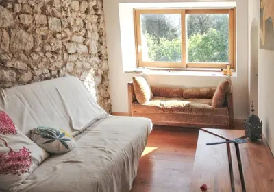 a living room with a couch and a window at Maison de campagne avec vue sur la montagne à Puivert. in Puivert