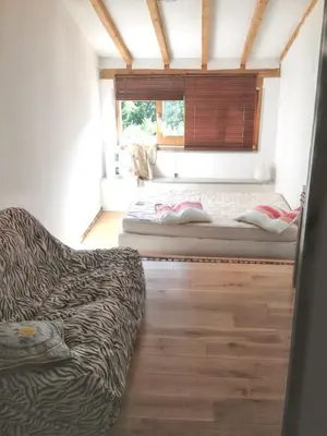 a bedroom with a bed and a window with a couch at Maison de campagne avec vue sur la montagne à Puivert. in Puivert