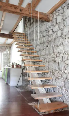 a wooden staircase in a stone wall at Maison de campagne avec vue sur la montagne à Puivert. in Puivert