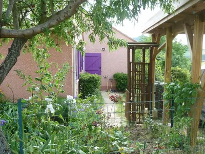a garden with a purple door in front of a house at Le gite de Cristal proche Bugarach in Granès