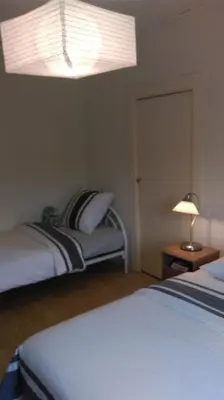 a bedroom with two beds and a large light at Le Moulin de l'Abbé in Sorèze