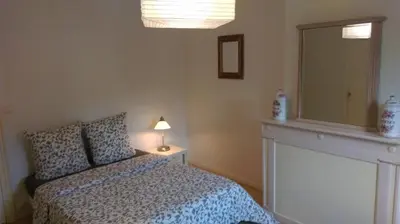 a bedroom with a bed and a mirror and a lamp at Le Moulin de l'Abbé in Sorèze