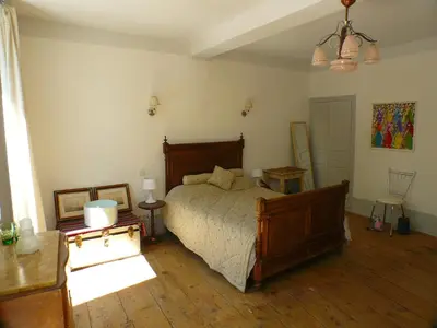 a bedroom with a bed and a wooden floor at Nidélice Chambre d'hôtes in Quillan