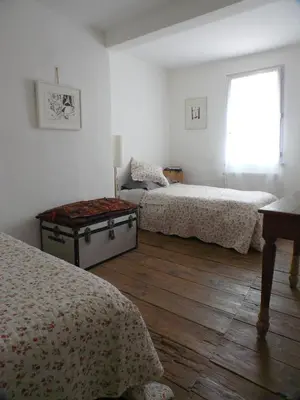 a bedroom with two beds and a window at Nidélice Chambre d'hôtes in Quillan