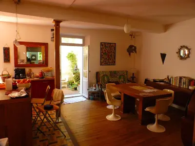 a living room with a wooden table and chairs at Nidélice Chambre d'hôtes in Quillan