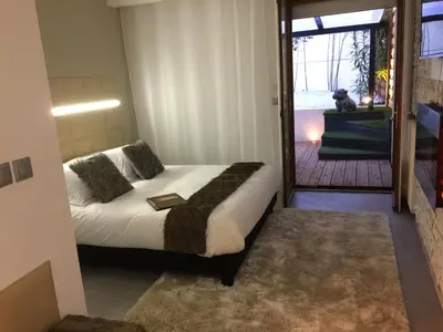 a bedroom with a bed and a door to a balcony at LOFT SPA - Côté château. in Carcassonne