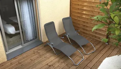 two chairs sitting on a porch next to a window at LOFT SPA - Côté château. in Carcassonne