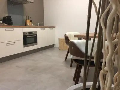 a kitchen with white cabinets and a table and chairs at LOFT SPA - Côté château. in Carcassonne