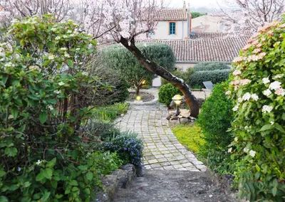 a garden with a stone path in front of a house at Sous les courtines in Carcassonne