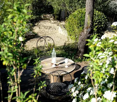 a wooden table with two chairs and a bottle of water on it at Sous les courtines in Carcassonne