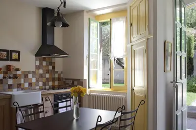 a kitchen with a table and chairs and a window at Sous les courtines in Carcassonne