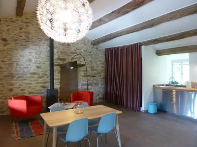 a dining room with a table and chairs and a chandelier at La Bouriotte Gîtes in Labastide-Rouairoux