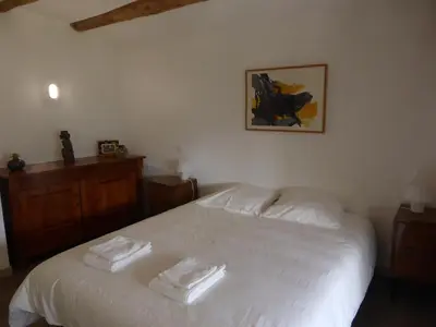 a bedroom with a white bed with two towels on it at La Bouriotte Gîtes in Labastide-Rouairoux