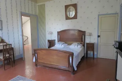 a bedroom with a wooden bed with two pillows at Le Domaine de Fraissinet in Ouveillan