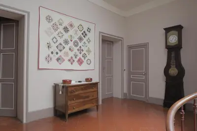 a room with a dresser and a clock on the wall at Le Domaine de Fraissinet in Ouveillan