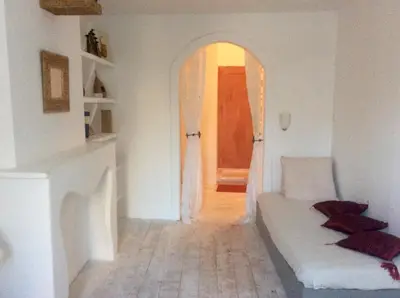 a living room with a white couch and an open door at La planque in Gruissan