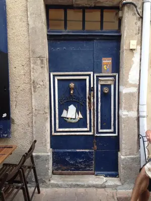 a blue door with a picture of a boat on it at La planque in Gruissan