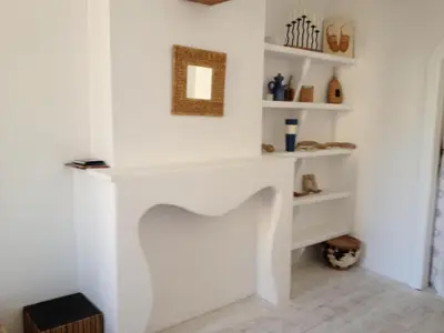 a white fireplace in a room with white shelves at La planque in Gruissan