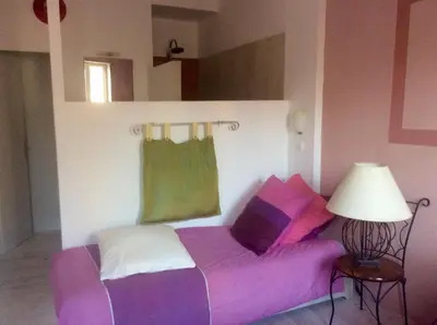 a bed with purple and green sheets in a room at La planque in Gruissan