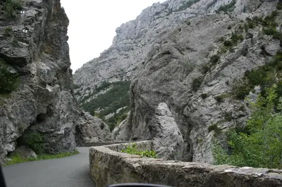 a mountain road with a road cutting through a canyon at Gite Soyez in Vélieux