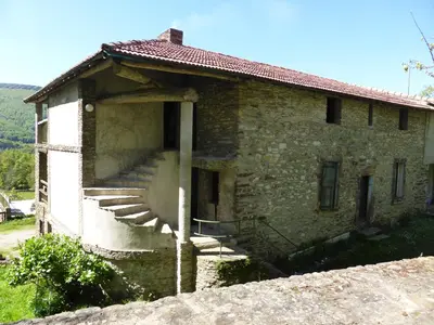 a stone house with stairs on the side of it at La Bouriotte Chambre d'hôtes Bouton D'Or in Labastide-Rouairoux