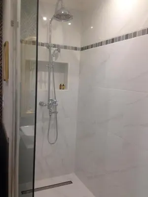 a bathroom with a shower with a glass door at La Glycine Blanche in Pomas