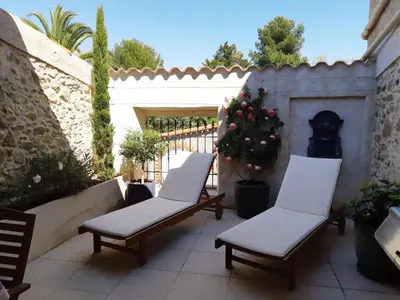 a patio with two chairs and a fireplace at La Glycine Blanche in Pomas