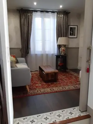 a living room with a couch and a table at La Glycine Blanche in Pomas