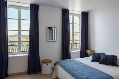 a bedroom with a bed and a large window at La Maison des Vendangeurs sur Mer in Gruissan