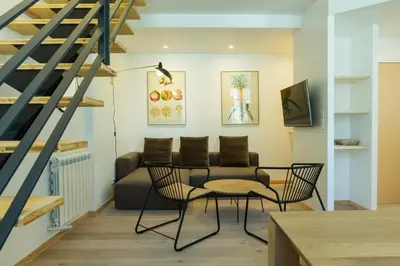 a living room with a couch and a table and chairs at La Maison des Vendangeurs sur Mer in Gruissan
