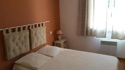 a bedroom with a white bed and a window at L'Ispanina in Thézan-des-Corbières