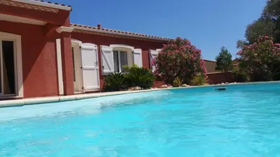 a swimming pool in front of a house at L'Ispanina in Thézan-des-Corbières