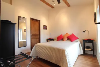 a bedroom with a bed with red pillows on it at Gites de Gabrielle in Capestang