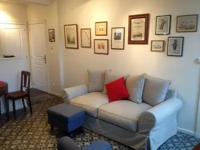 a living room with a white couch with a red pillow at Gites de Gabrielle in Capestang