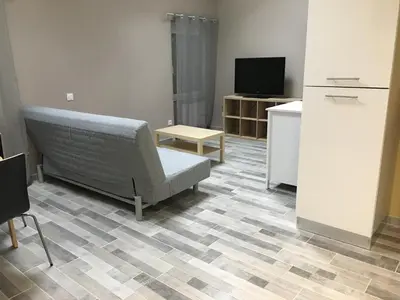a living room with a couch and a tv at Appartements 