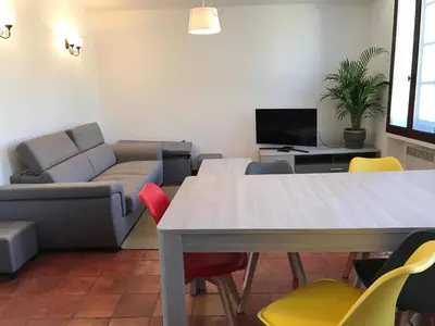 a living room with a table and chairs and a couch at Appartement au coeur de Carcassonne in Carcassonne