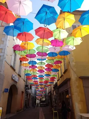 a bunch of colorful umbrellas hanging from a building at Appartement au coeur de Carcassonne in Carcassonne