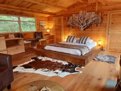 a bedroom with a bed in a log cabin at Domaine de la Vitarelle Glamping in Villanière