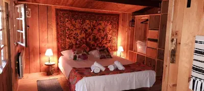 a bedroom with a bed in a wooden room at Domaine de la Vitarelle Glamping in Villanière