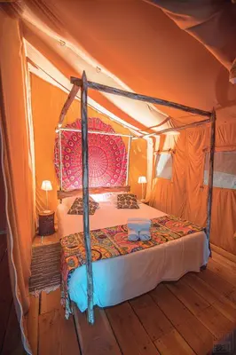 a bedroom with a bed in a tent at Domaine de la Vitarelle Glamping in Villanière