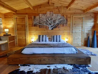 a bedroom with a bed in a log cabin at Domaine de la Vitarelle Glamping in Villanière