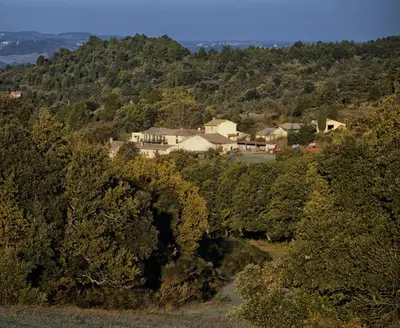 a house in the middle of a forest of trees at Domaine De Fraisse in Leuc