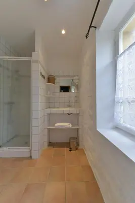 a bathroom with a shower and a tiled wall at Domaine De Fraisse in Leuc